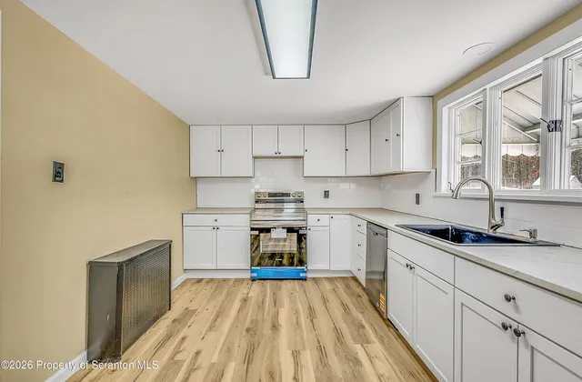 a kitchen with granite countertop white cabinets and white appliances