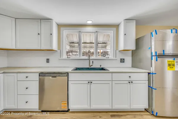 a kitchen with stainless steel appliances granite countertop a sink a refrigerator and a granite counter tops