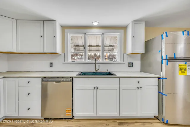 a kitchen with stainless steel appliances granite countertop a sink a refrigerator and a granite counter tops