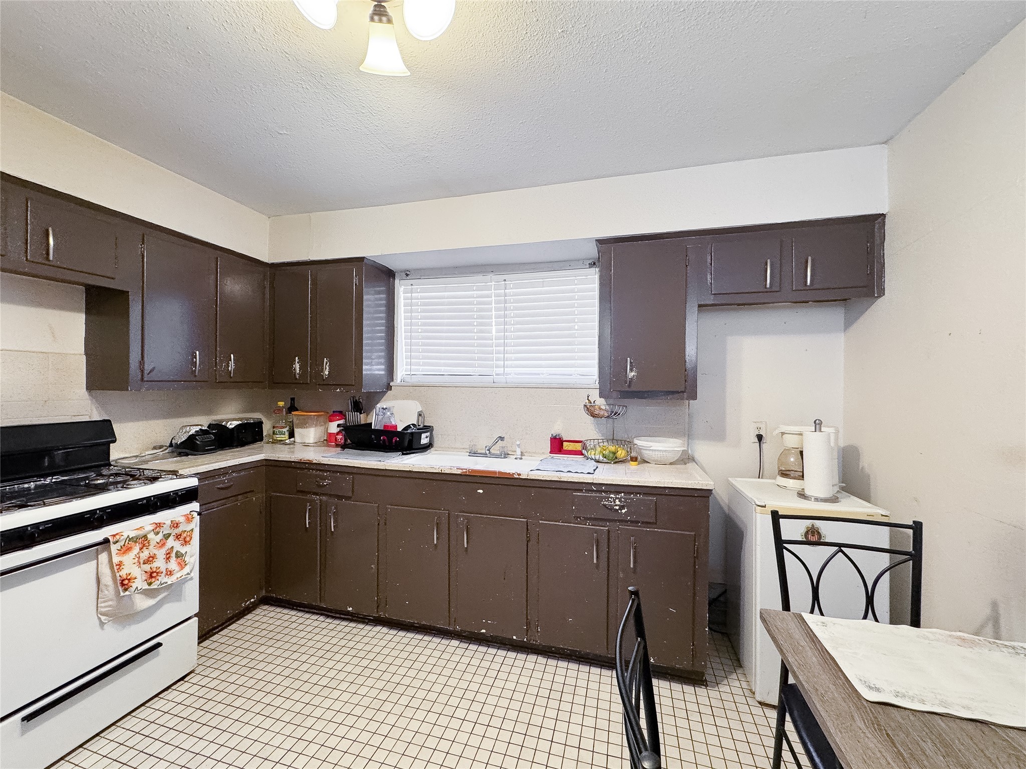 2712 Oakcliff Street Houston, TX 77023 - Photo 21 of 30 a kitchen with a sink a stove a refrigerator cabinets and dining table
