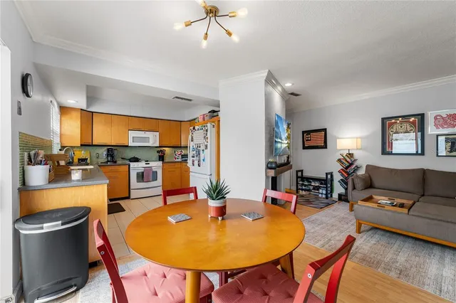 a living room with furniture and a dining table with wooden floor