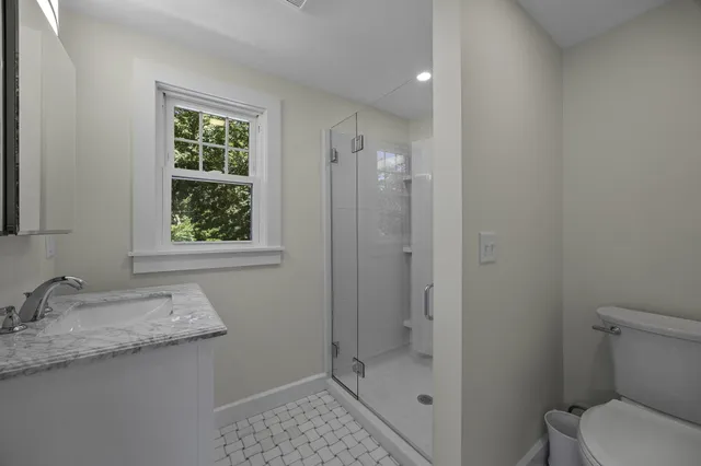 a picture of a room with two white bed and a refrigerator