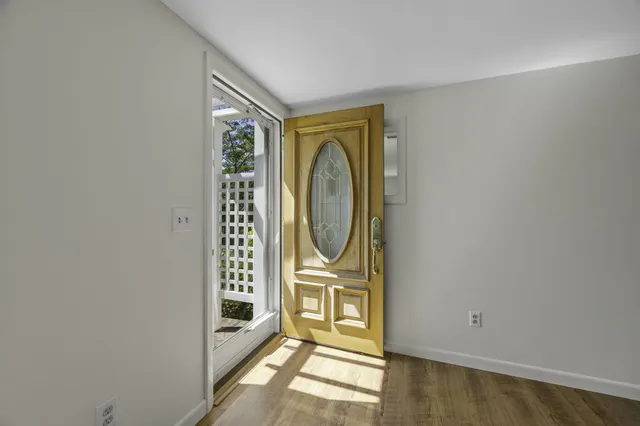 a view of an empty room with window and refrigerator