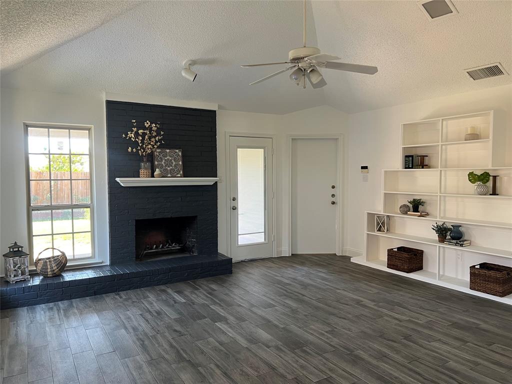 1758 Castille Drive Carrollton, TX 75007 - Photo 3 of 19 a living room with a fireplace with wooden floor