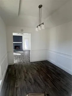 a view of empty room with wooden floor and fireplace