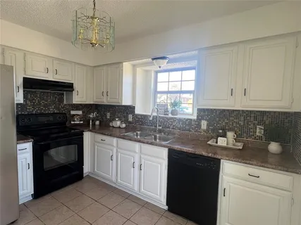 a kitchen with stainless steel appliances granite countertop a sink a stove a microwave and cabinets