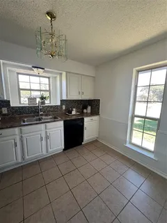 a kitchen with a sink window and cabinets