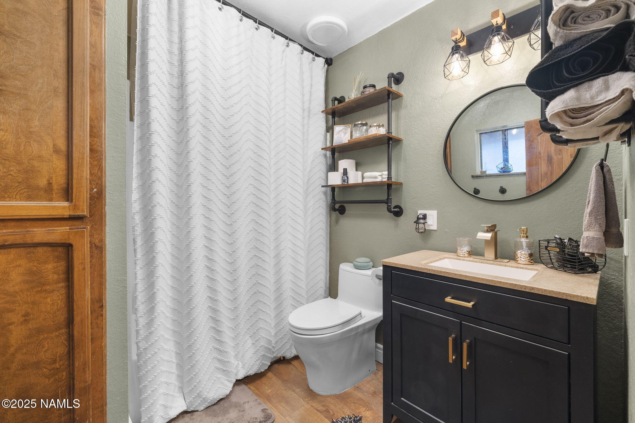 3628 East Pine Cone Drive Williams, AZ 86046 - Photo 12 of 23 a bathroom with a toilet a sink and a mirror