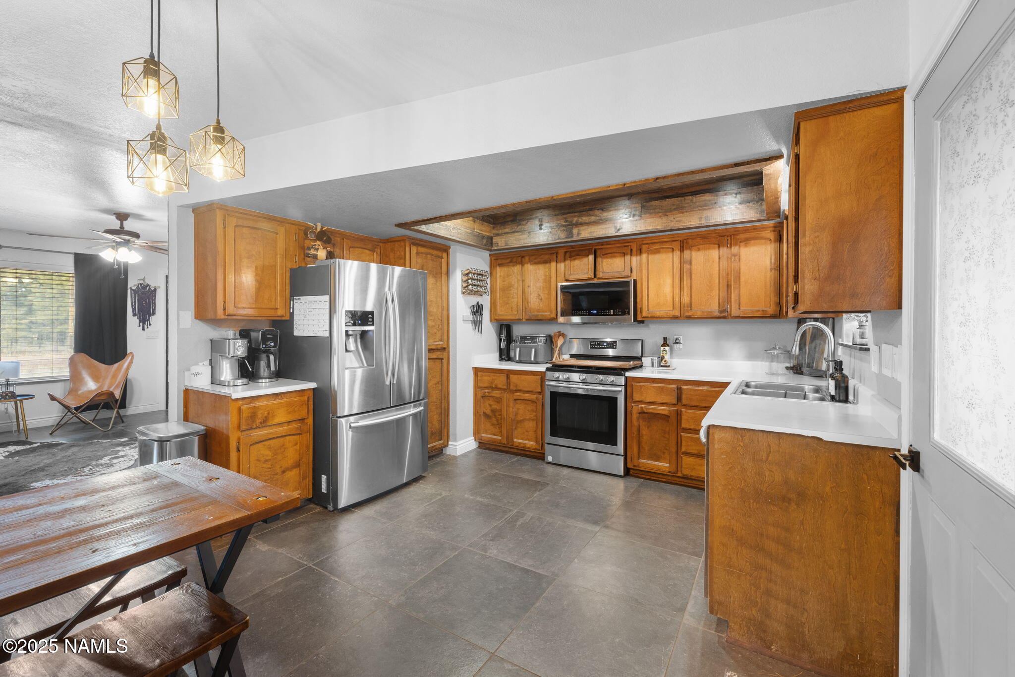 3628 East Pine Cone Drive Williams, AZ 86046 - Photo 2 of 23 a kitchen with a refrigerator a stove a sink dishwasher a oven with a dining table and chairs