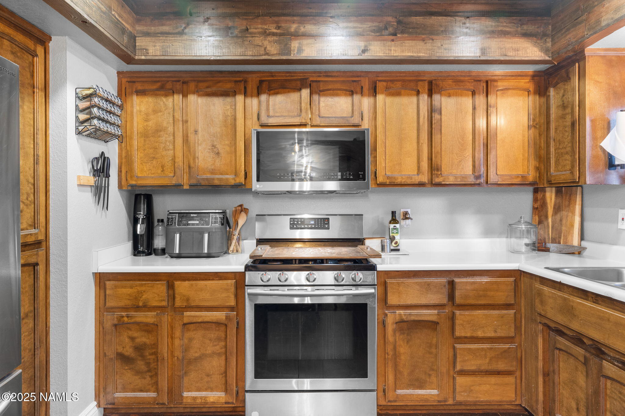 3628 East Pine Cone Drive Williams, AZ 86046 - Photo 4 of 23 a kitchen with granite countertop a stove a sink and a microwave