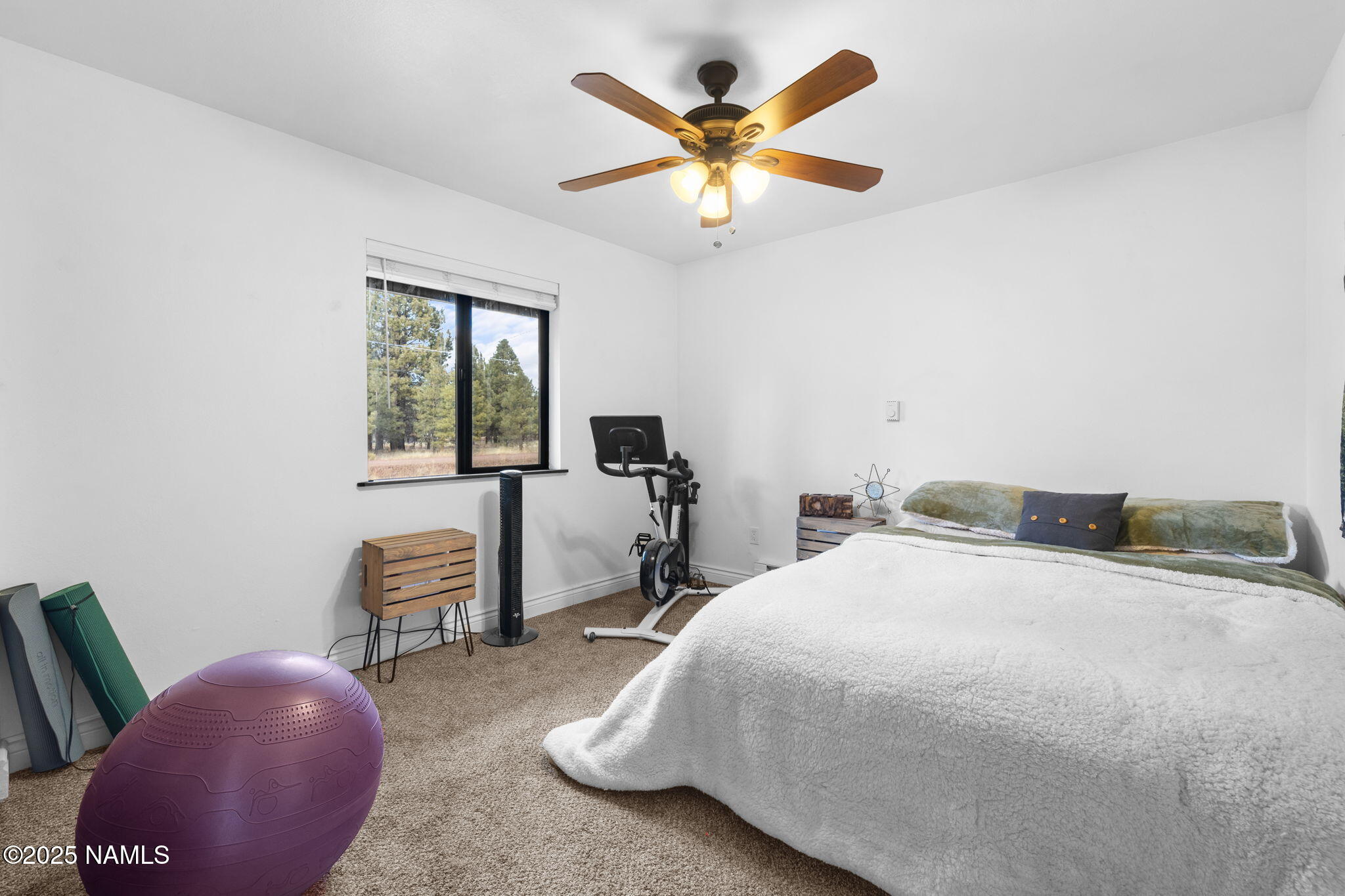 3628 East Pine Cone Drive Williams, AZ 86046 - Photo 10 of 23 a bedroom with a bed a chair and a chandelier