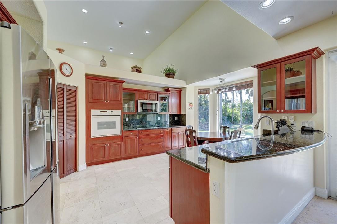 17400 Southwest 66th Street Southwest Ranches, FL 33331 - Photo 14 of 38 a kitchen with granite countertop a refrigerator and a sink