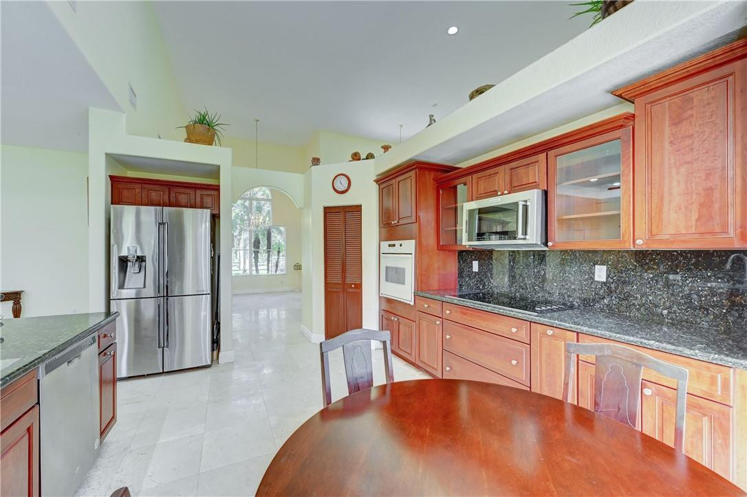 17400 Southwest 66th Street Southwest Ranches, FL 33331 - Photo 16 of 38 a large kitchen with stainless steel appliances granite countertop a refrigerator and a sink