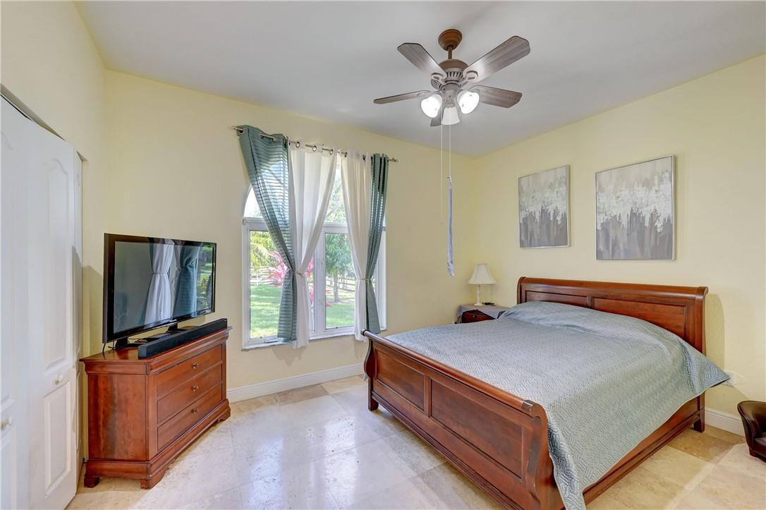 17400 Southwest 66th Street Southwest Ranches, FL 33331 - Photo 26 of 38 a bedroom with a bed and a flat screen tv