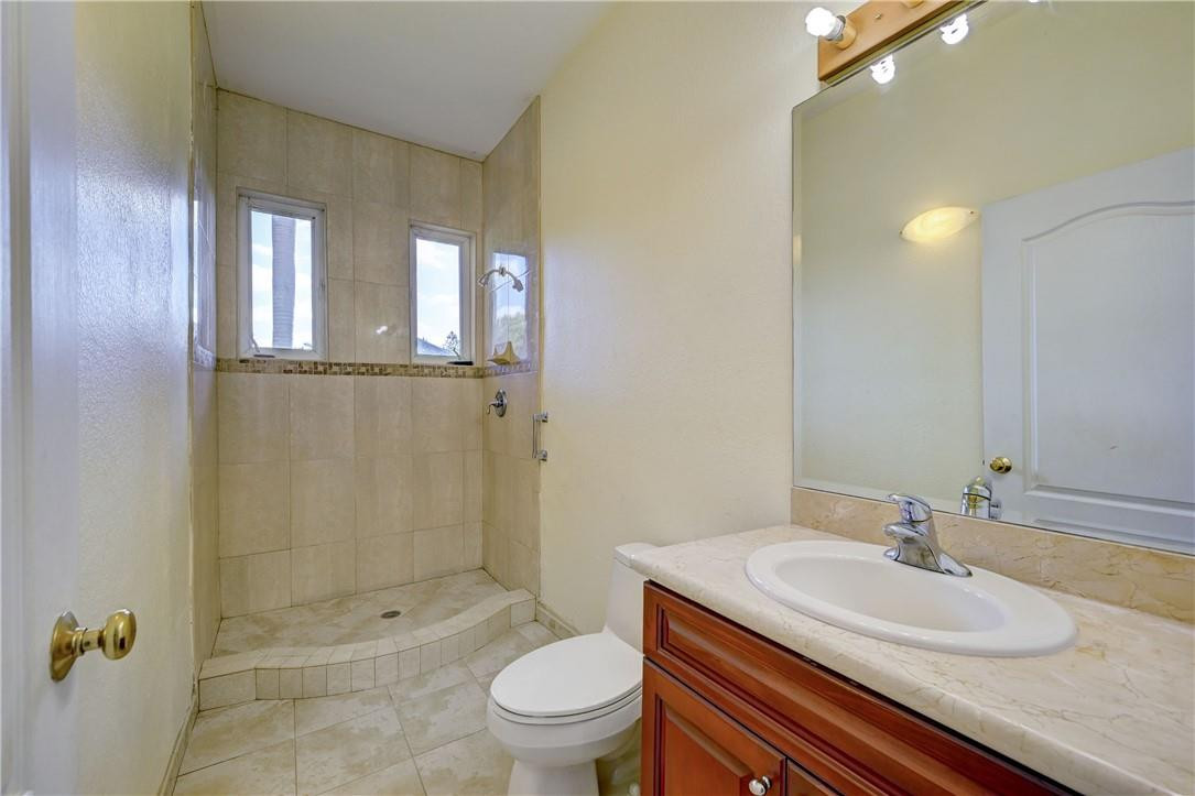 17400 Southwest 66th Street Southwest Ranches, FL 33331 - Photo 28 of 38 a bathroom with a granite countertop sink a toilet a mirror and shower