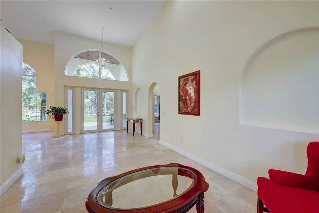 17400 Southwest 66th Street Southwest Ranches, FL 33331 - Photo 8 of 38 a dining room with wooden floor a chandelier a wooden table and chairs