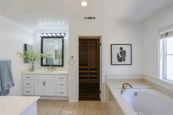 a bathroom with a tub sink and mirror