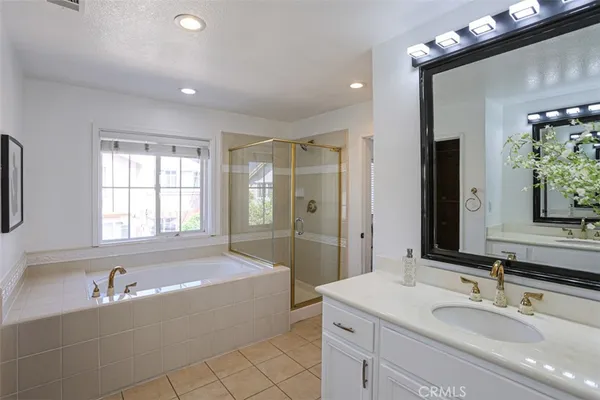 a bathroom with a tub sink and mirror