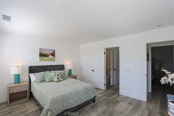 a bedroom with a bed and wooden floor