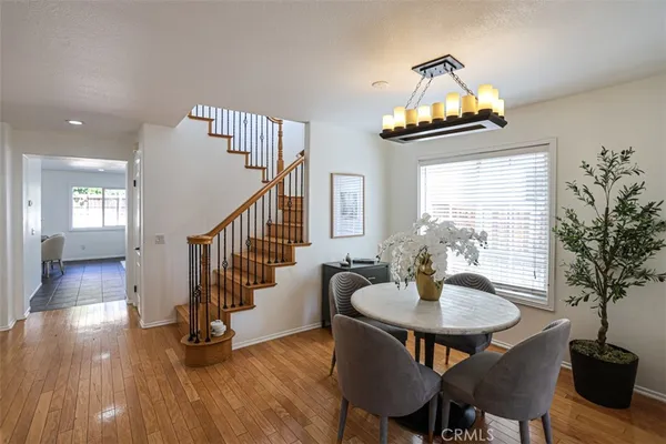 a dining room with furniture potted plants and wooden floor