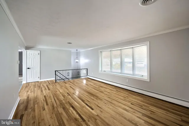 a view of a room with wooden floor and window