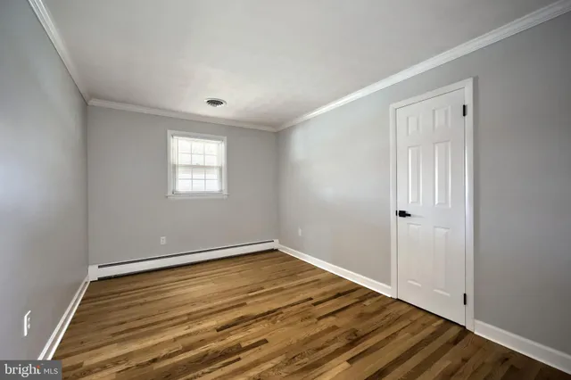 a view of a room with wooden floor and window