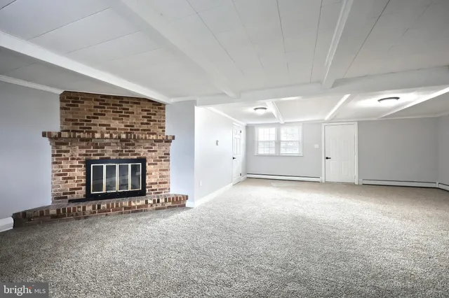 an empty room with a fireplace and window