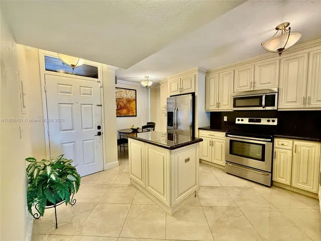 a kitchen with stainless steel appliances a stove cabinets and a refrigerator