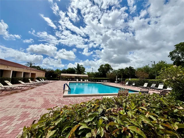 a view of a swimming pool with an outdoor seating and a yard