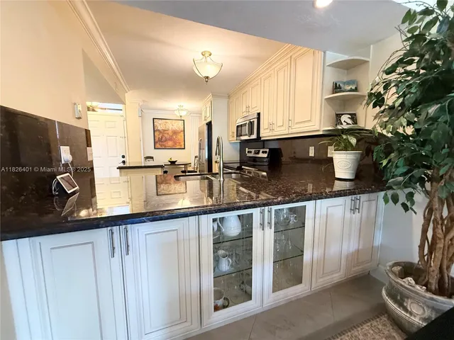 a kitchen with stainless steel appliances granite countertop a sink and a stove