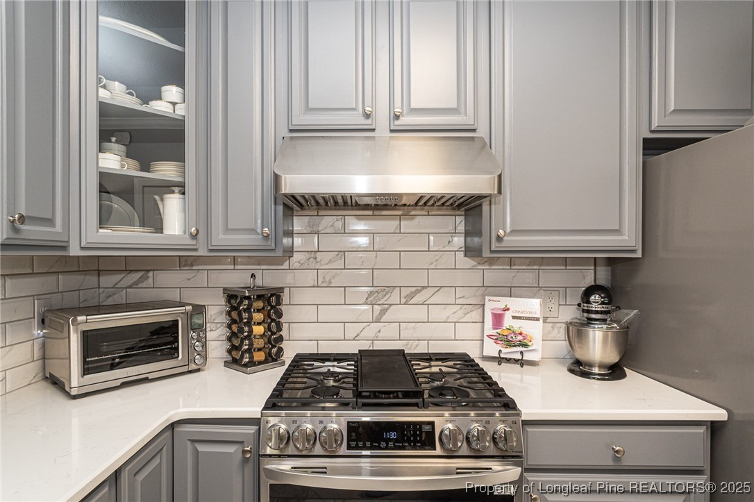 595 Whispering Pines Drive Spring Lake, NC 28390 - Photo 15 of 48 a kitchen with a stove and white cabinets