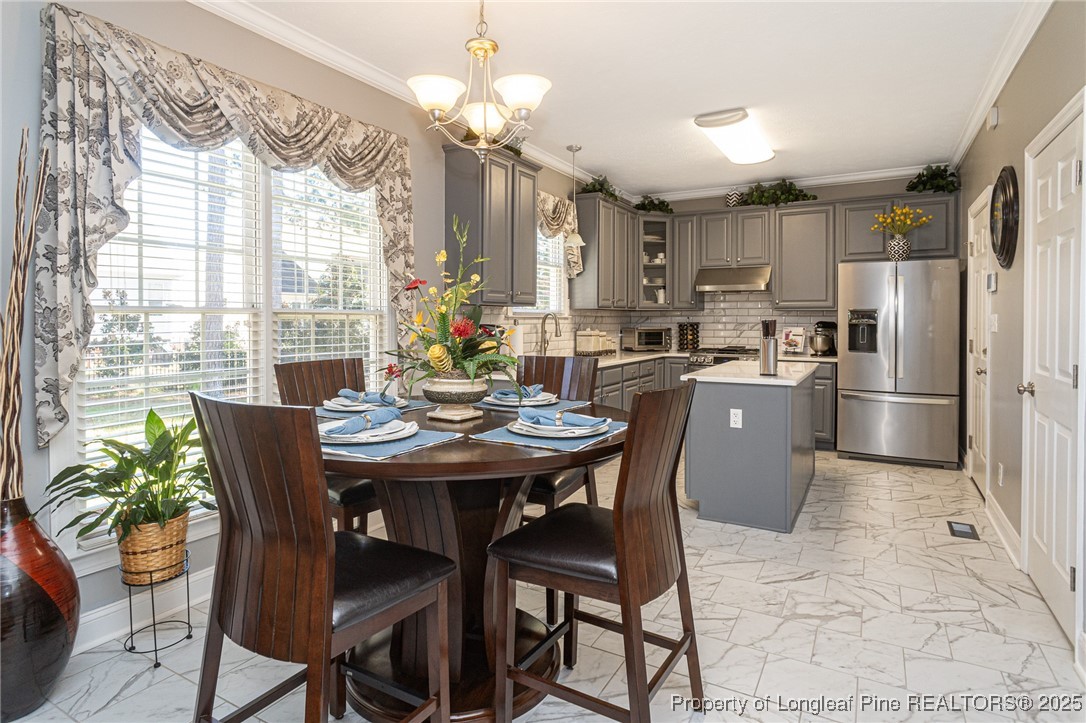 595 Whispering Pines Drive Spring Lake, NC 28390 - Photo 17 of 48 a kitchen with kitchen island a dining table and chairs