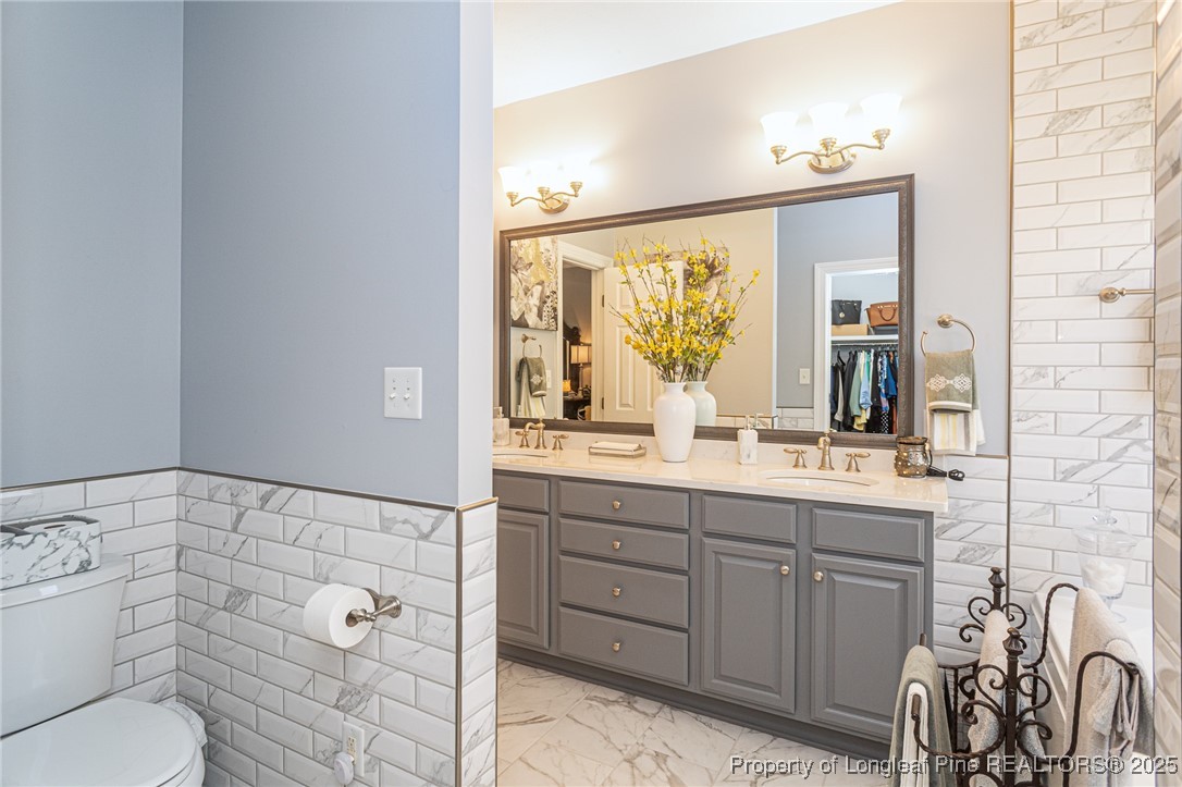 595 Whispering Pines Drive Spring Lake, NC 28390 - Photo 25 of 48 a bathroom with a granite countertop sink mirror and toilet