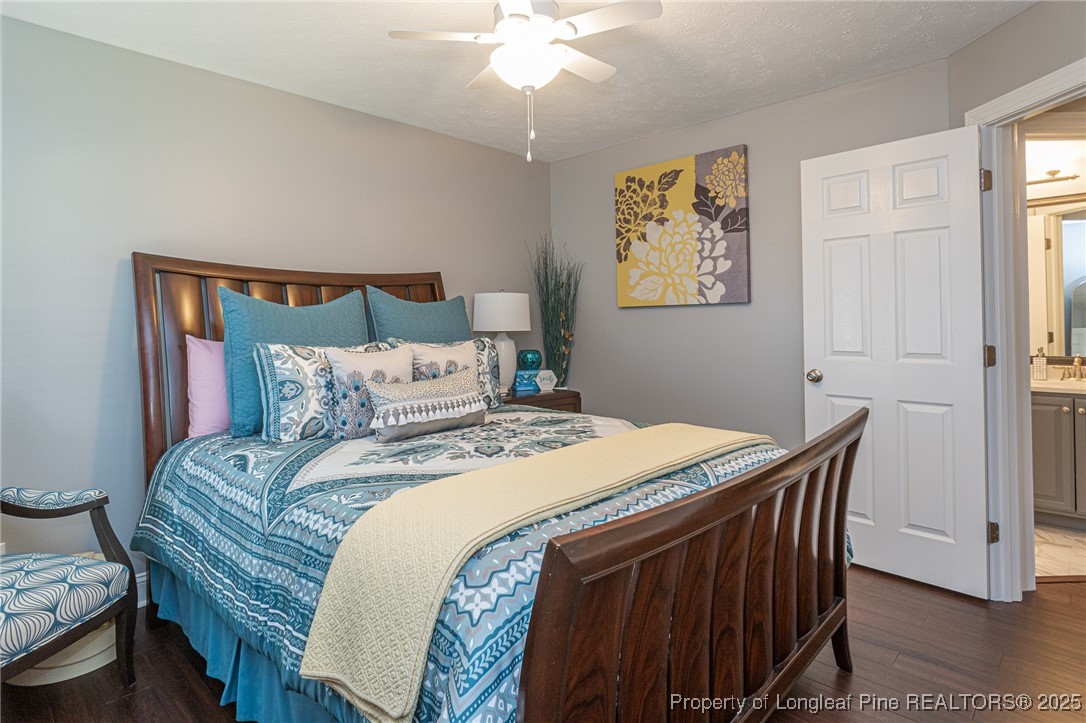 595 Whispering Pines Drive Spring Lake, NC 28390 - Photo 32 of 48 a bedroom with a bed and a chandelier