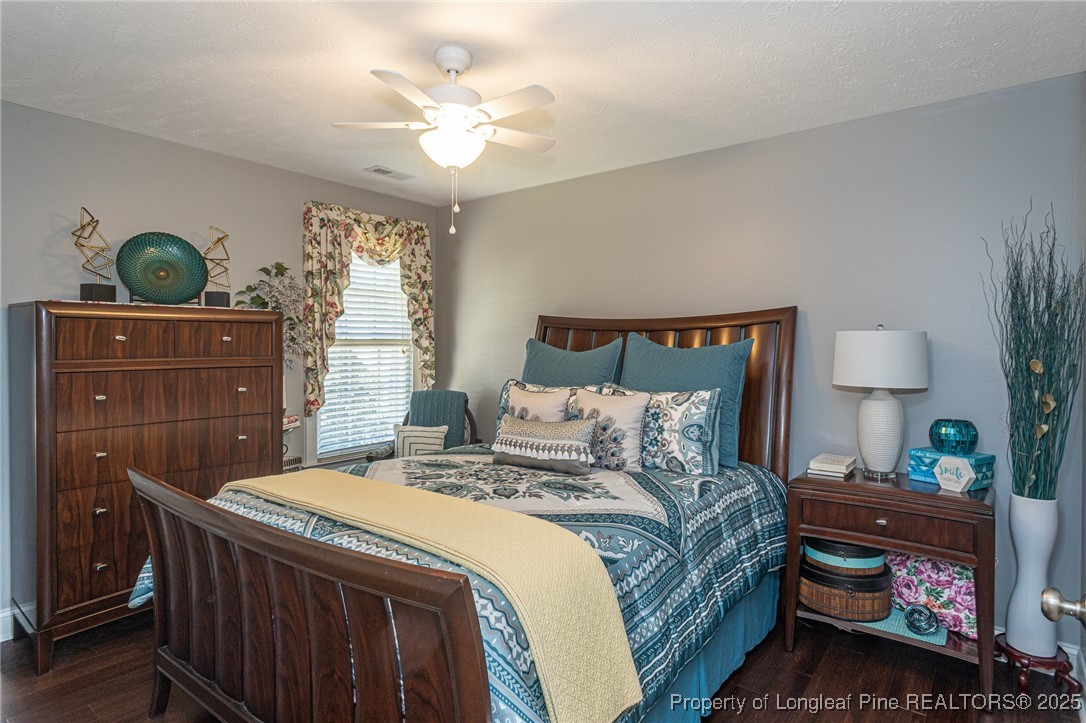 595 Whispering Pines Drive Spring Lake, NC 28390 - Photo 33 of 48 a bedroom with a bed and a lamp on dresser