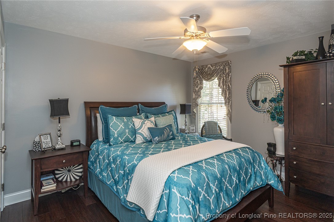 595 Whispering Pines Drive Spring Lake, NC 28390 - Photo 34 of 48 a bedroom with a large bed and a chandelier