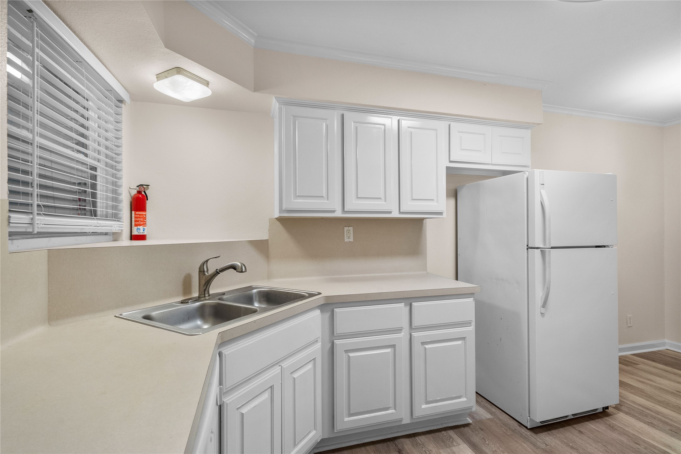 102 Strand Street, Unit 3 Galveston, TX 77550 - Photo 3 of 19 a kitchen with white cabinets sink and refrigerator
