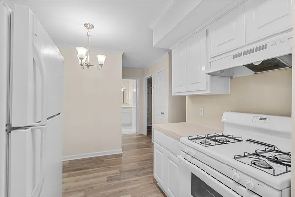 a kitchen with a stove and white cabinets