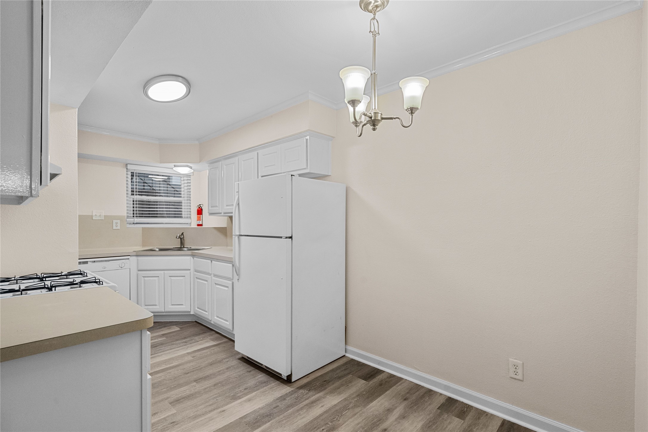 102 Strand Street, Unit 3 Galveston, TX 77550 - Photo 6 of 19 a view of a kitchen with a sink dishwasher a refrigerator with wooden floor