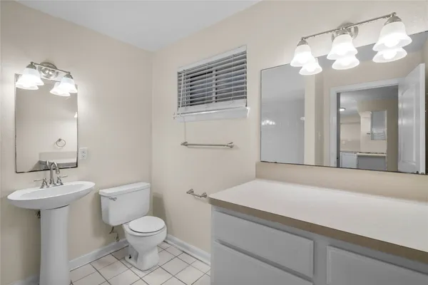 a bathroom with a sink a toilet and a mirror