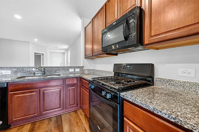 a kitchen with stainless steel appliances granite countertop a stove microwave and sink