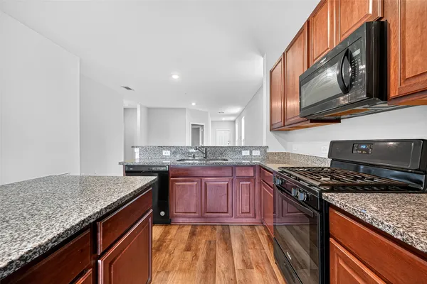 a kitchen with stainless steel appliances granite countertop a stove sink and cabinets