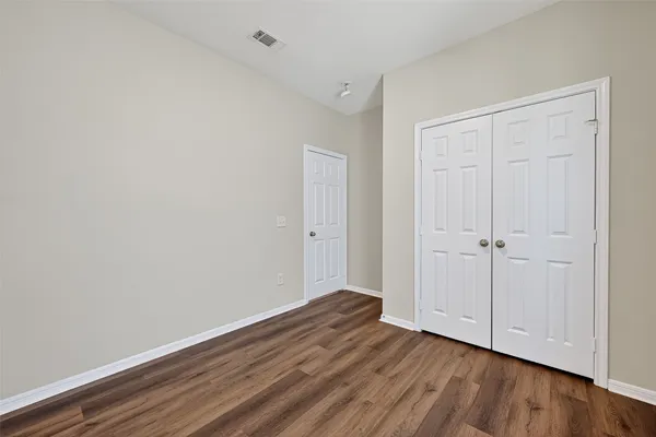 a view of an empty room with wooden floor