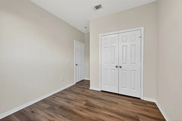 a view of an empty room with wooden floor