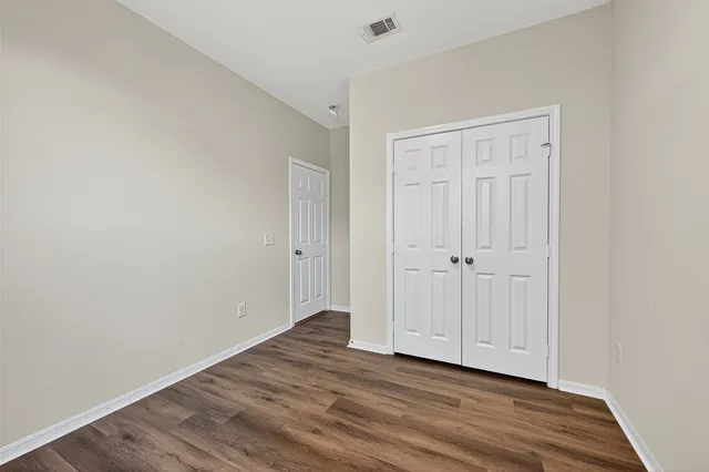 a view of an empty room with wooden floor