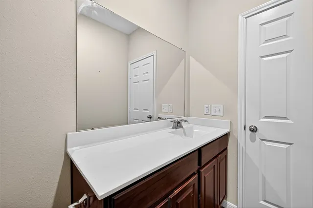 a bathroom with a sink a mirror and a vanity