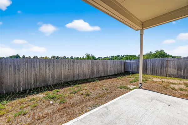 a view of a house with backyard and wooden fence