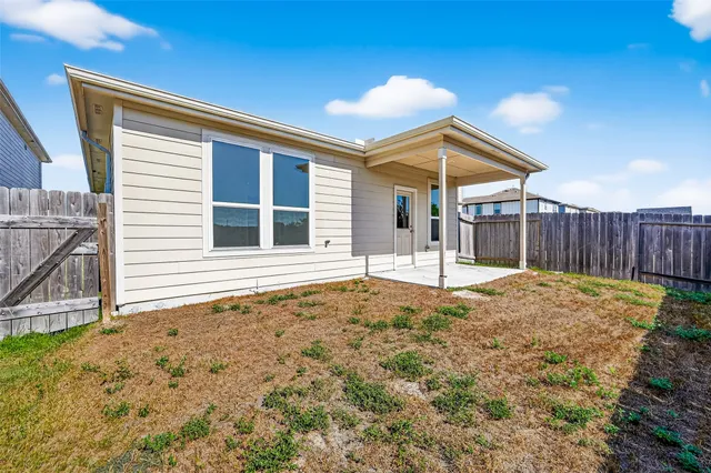 a view of backyard with wooden fence