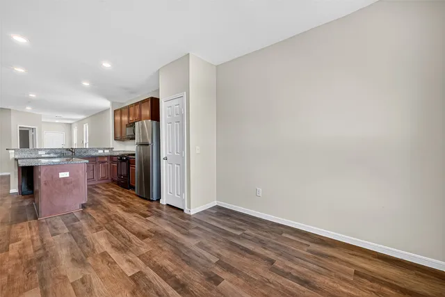a view of kitchen with kitchen island microwave and cabinets