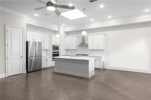 a large kitchen with a large window stainless steel appliances and cabinets